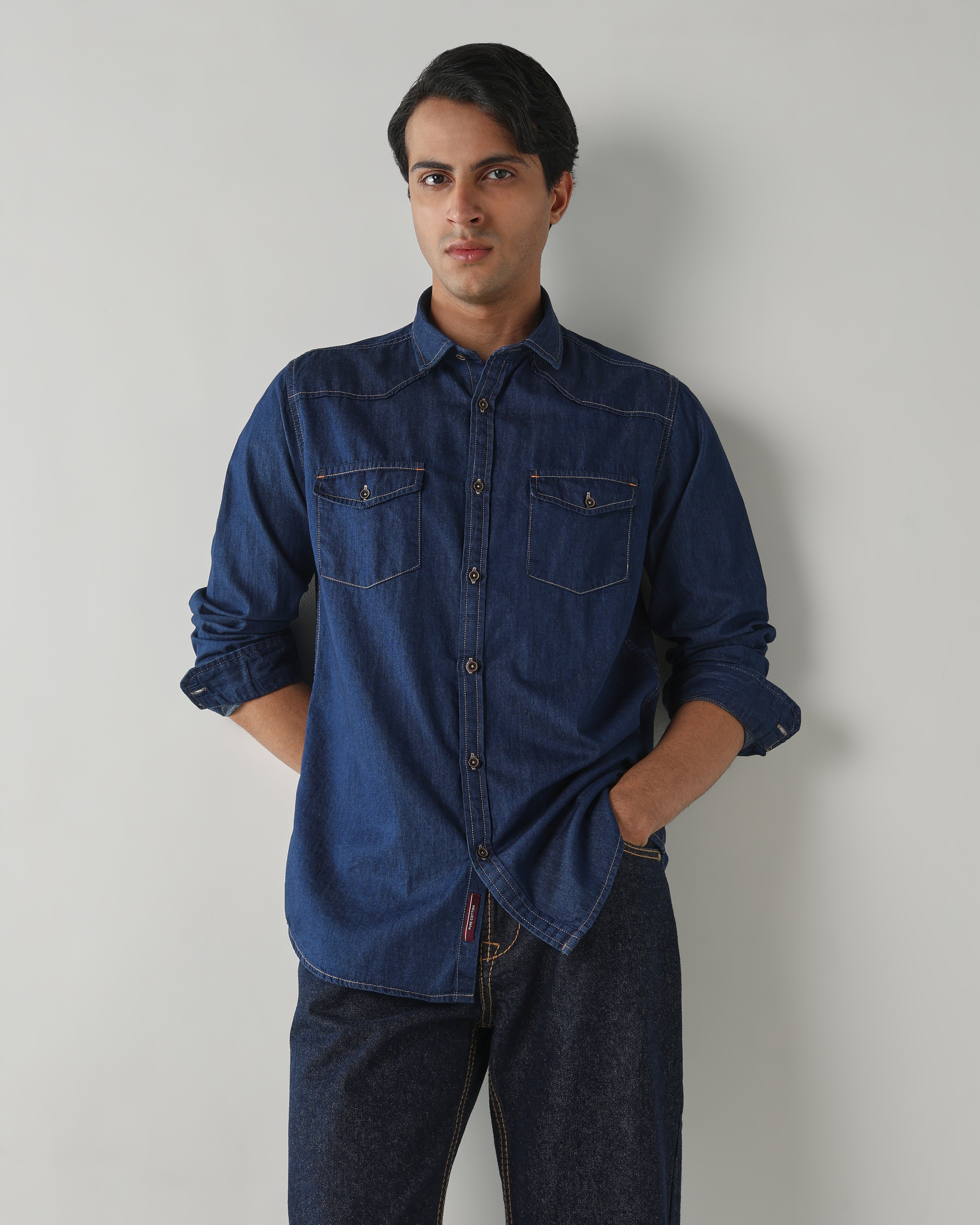 Man wearing a blue denim shirt against a plain background